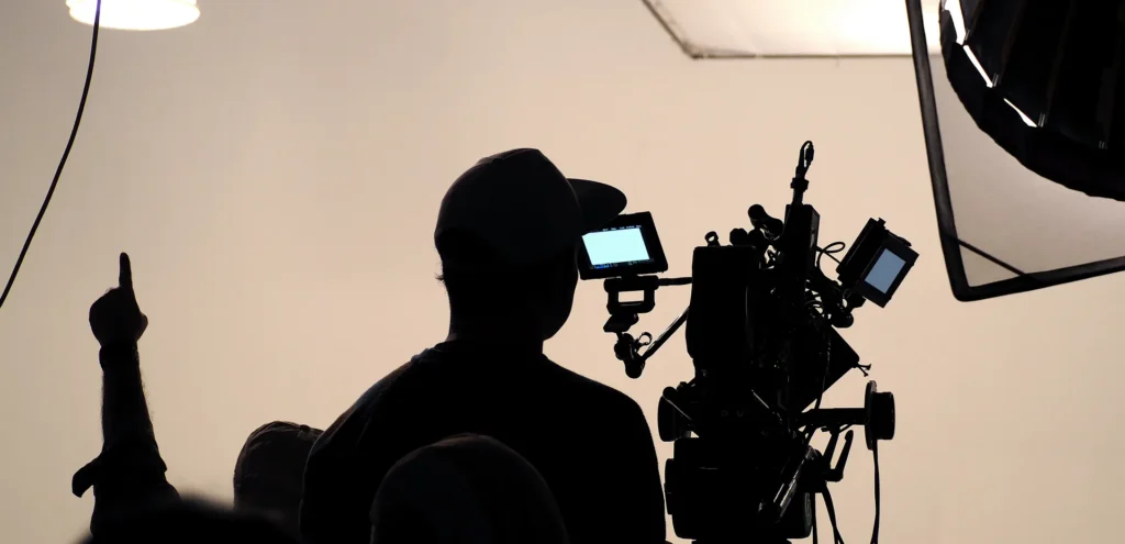Silhouette eines Kameramanns mit Cinema Kamera und Monitor im Studio